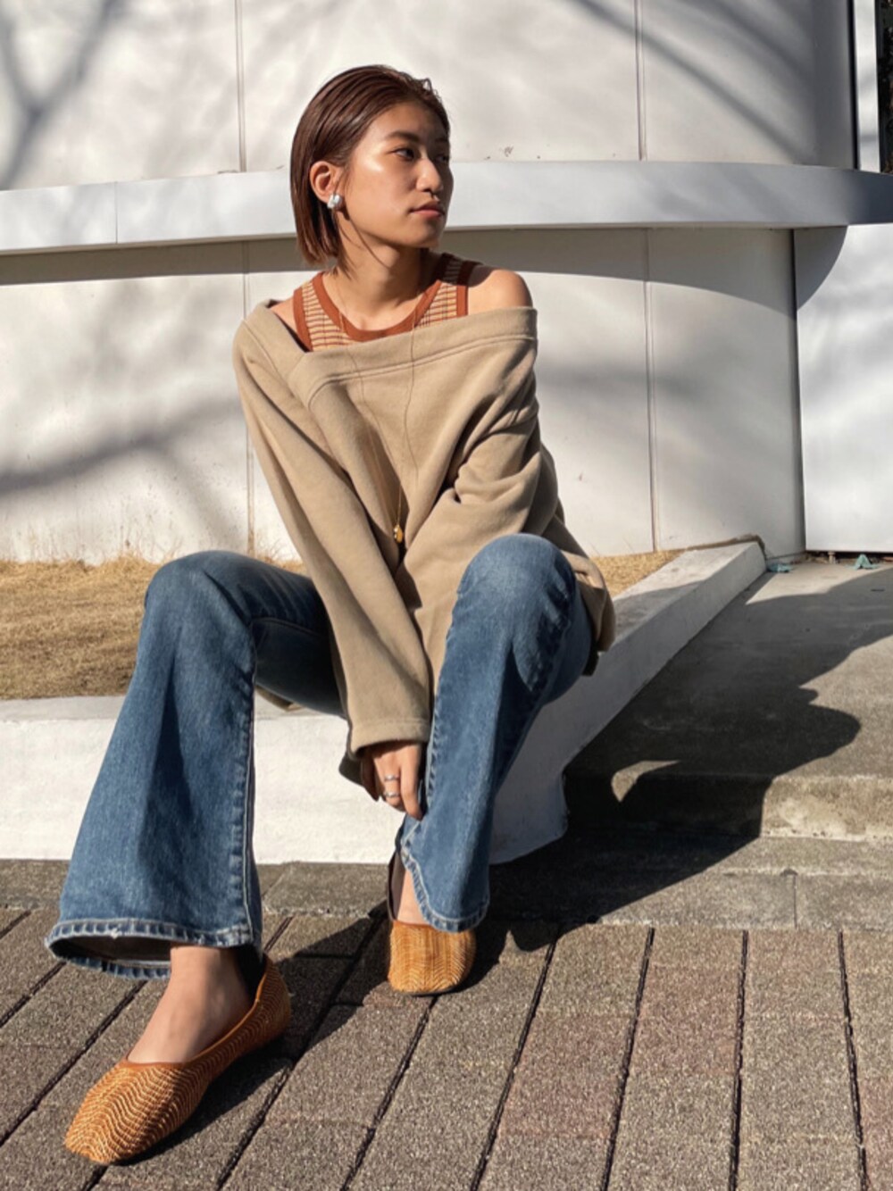 ブラウン系のその他シューズ、ベージュ系のスウェット、ブルー系のデニムパンツを着用したレディースの冬コーディネートの1枚目の写真