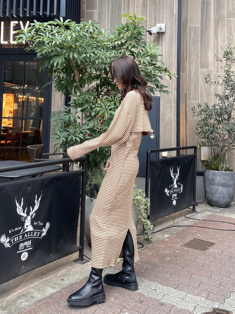 ブラウン系のワンピースを着用したレディースの冬コーディネートの1枚目の写真