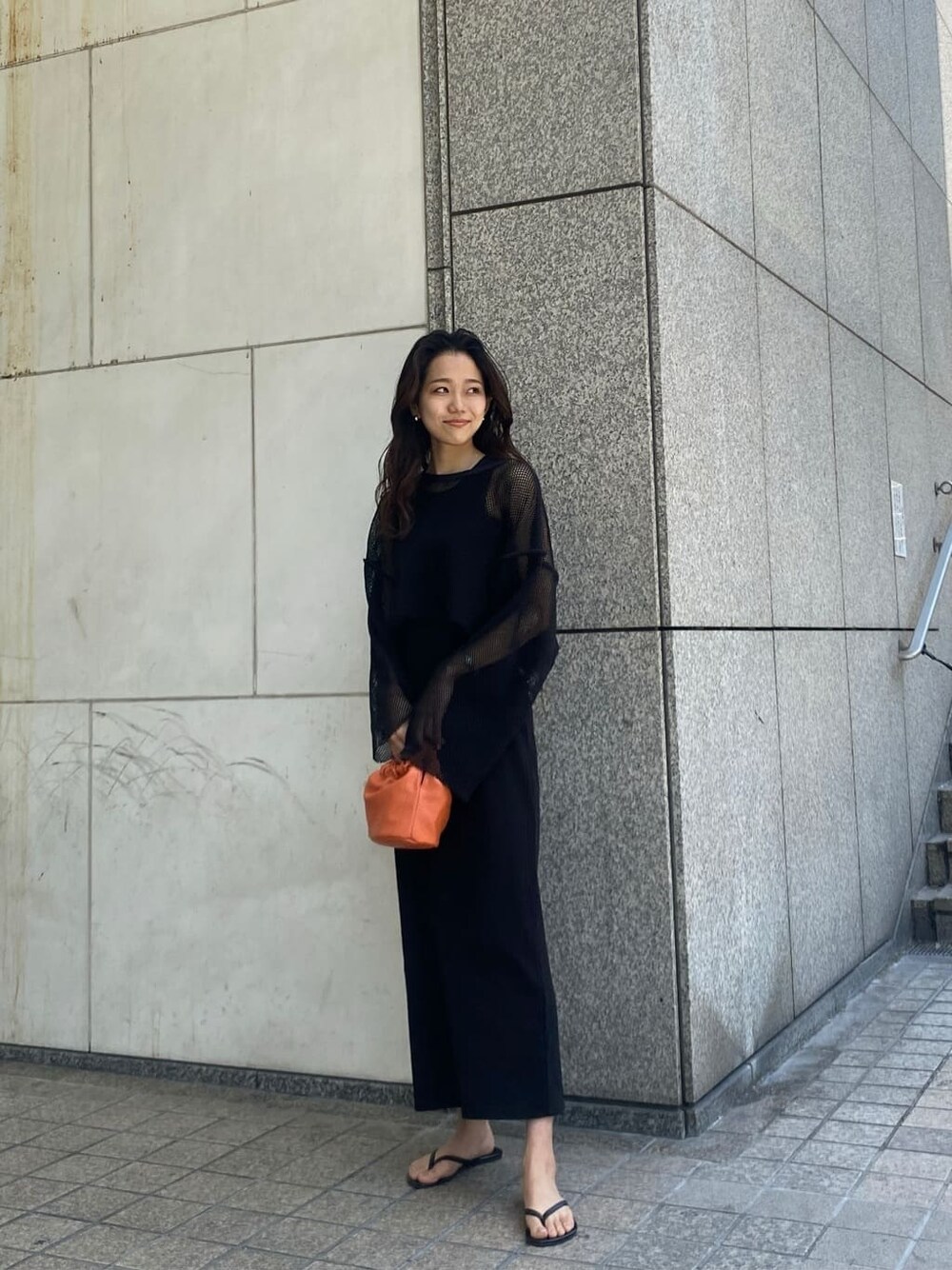 ブラック系のTシャツ/カットソー、ブラック系のワンピース、オレンジ系のハンドバッグを着用したレディースの春コーディネートの1枚目の写真