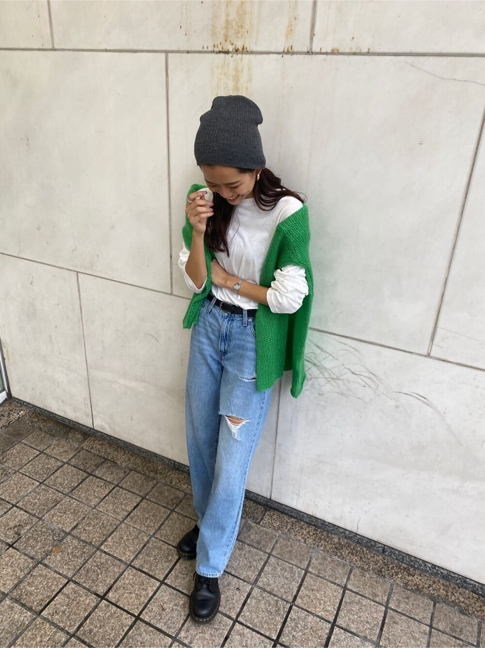 ホワイト系のTシャツ/カットソー、グリーン系のニット/セーター、ブラック系のベルトを着用したレディースの秋コーディネートの1枚目の写真