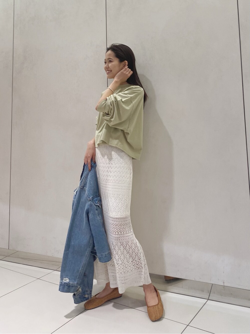 ブルー系のデニムジャケット、ホワイト系のスカート、ブラウン系のその他シューズを着用したレディースの春コーディネートの1枚目の写真