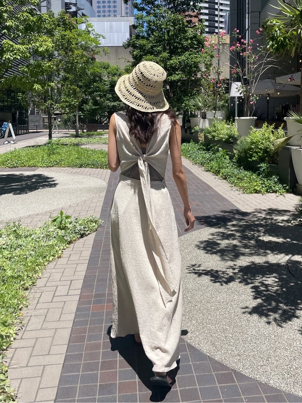 ブラック系のサンダル、ホワイト系のワンピース、ベージュ系のハットを着用したレディースの夏コーディネートの1枚目の写真