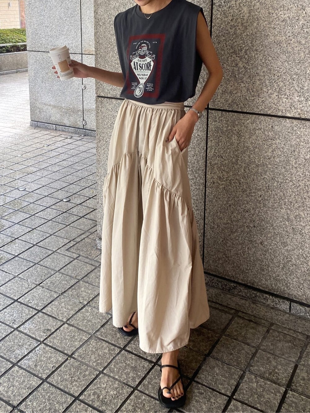 ホワイト系のスカート、グレー系のタンクトップを着用したレディースの夏コーディネートの1枚目の写真