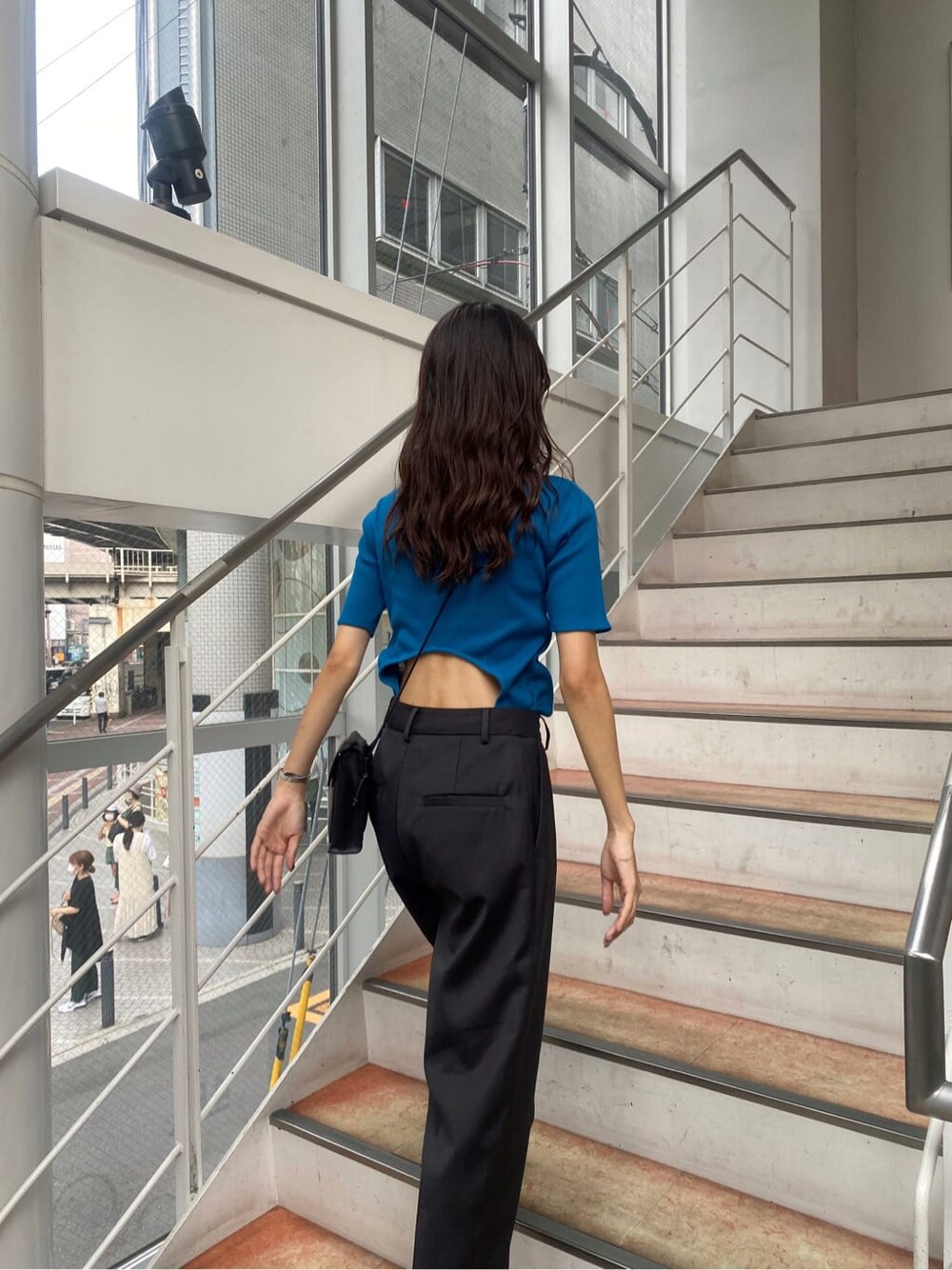 ブルー系のTシャツ/カットソー、グレー系のスラックスを着用したレディースの夏コーディネートの1枚目の写真