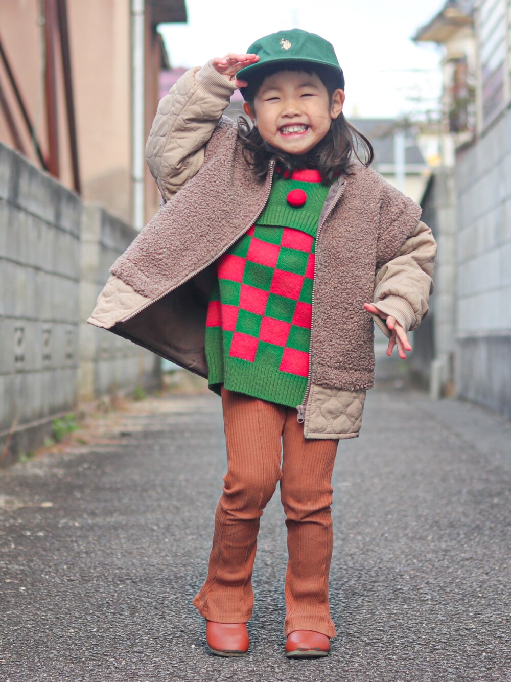グリーン系のニット/セーター、ベージュ系のその他アウター、ブラウン系のパンツを着用したキッズの冬コーディネートの1枚目の写真
