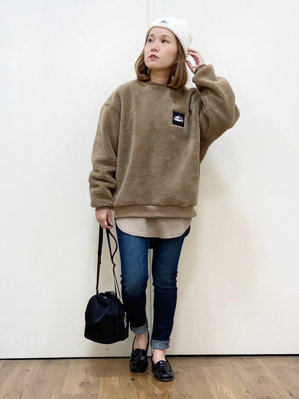 ブルー系のデニムパンツ、ブラック系のローファー、ブラック系のショルダーバッグを着用したレディースの秋コーディネートの1枚目の写真