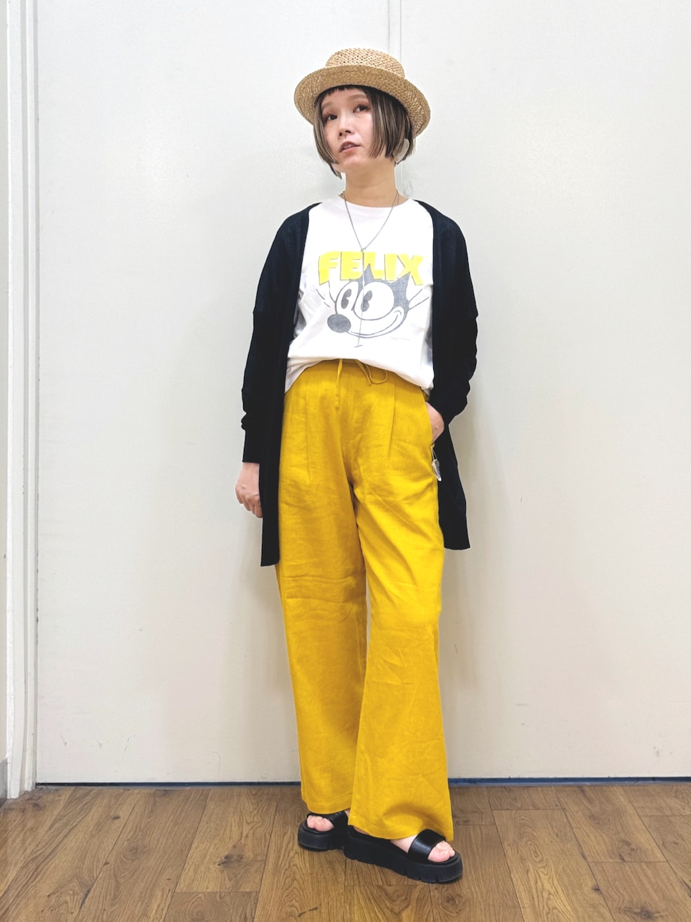 ブラック系のカーディガン/ボレロ、ホワイト系のTシャツ/カットソー、ブラック系のサンダルを着用したレディースの春コーディネートの1枚目の写真