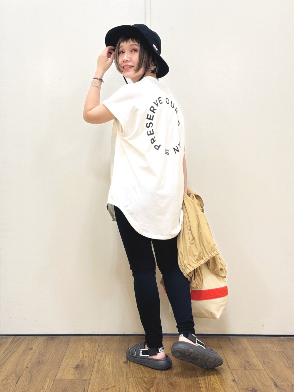 ホワイト系のTシャツ/カットソー、ブラック系のその他パンツ、ブラック系のサンダルを着用したレディースの春コーディネートの1枚目の写真