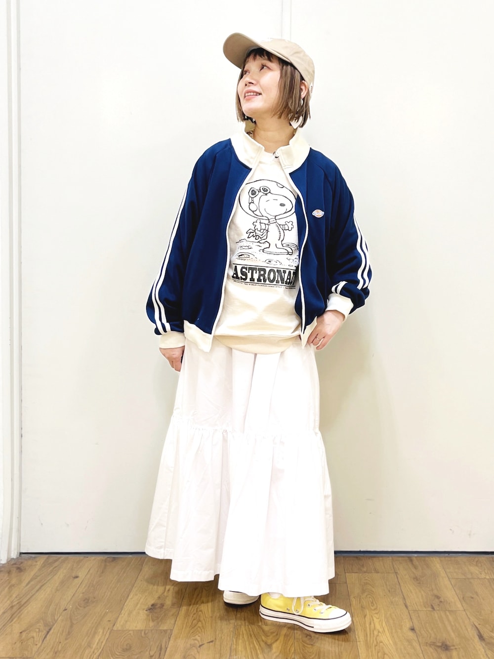 ホワイト系のTシャツ/カットソー、ホワイト系のスカート、イエロー系のスニーカーを着用したレディースの冬コーディネートの1枚目の写真