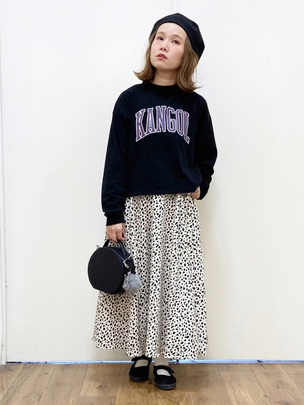 ブラック系のTシャツ/カットソー、ホワイト系のスカート、ブラック系のスニーカーを着用したレディースの秋コーディネートの1枚目の写真