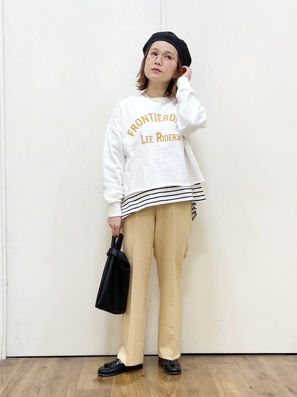 グレー系のショルダーバッグ、ホワイト系のスウェット、ホワイト系のTシャツ/カットソーを着用したレディースの冬コーディネートの1枚目の写真