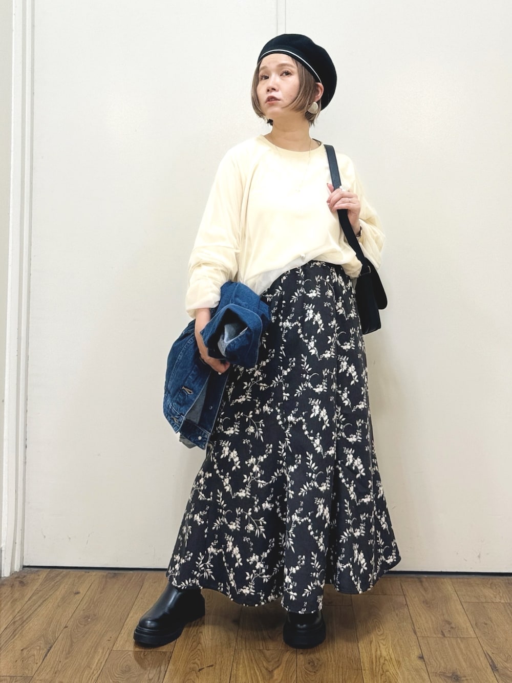 ブルー系のデニムジャケット、ブラック系のスカート、ブラック系のショルダーバッグを着用したレディースの秋コーディネートの1枚目の写真