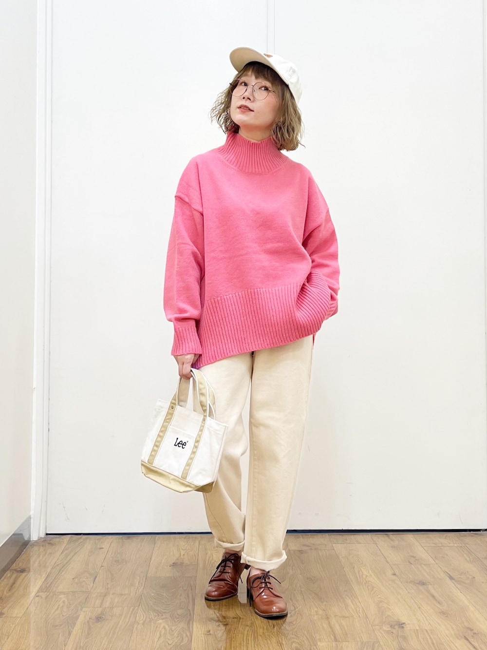 ピンク系のニット/セーター、ホワイト系のデニムパンツ、ブラウン系のドレスシューズを着用したレディースの秋コーディネートの1枚目の写真