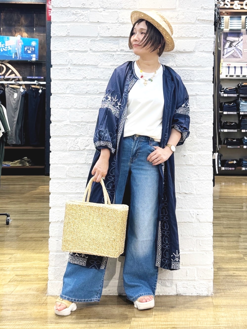 ホワイト系のTシャツ/カットソー、ブルー系のデニムパンツ、ゴールド系のハンドバッグを着用したレディースの夏コーディネートの1枚目の写真