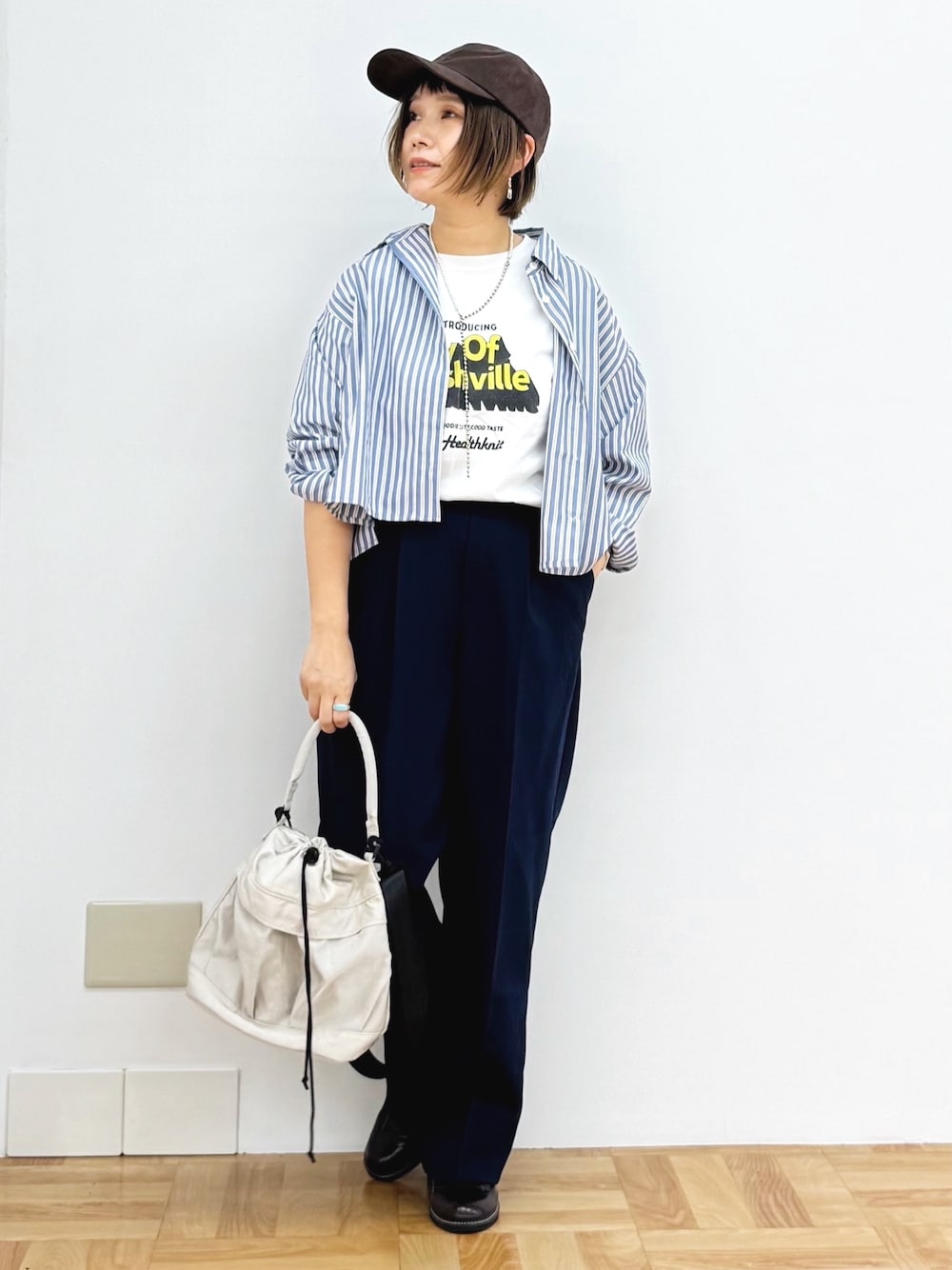 ホワイト系のショルダーバッグ、ブラウン系のドレスシューズ、ブルー系のその他パンツを着用したレディースの秋コーディネートの1枚目の写真