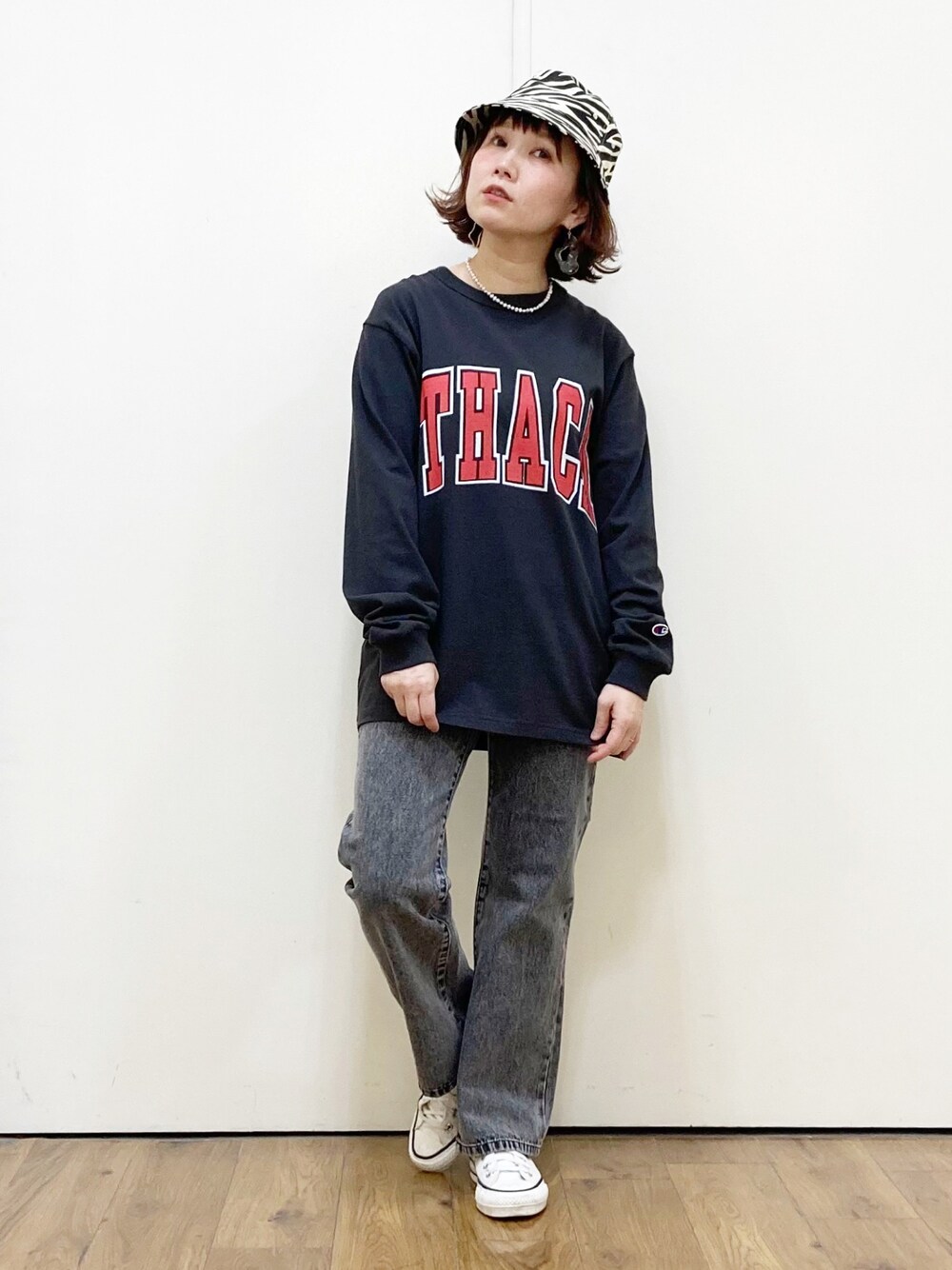 グレー系のTシャツ/カットソー、ブラック系のデニムパンツ、ホワイト系のスニーカーを着用したレディースの春コーディネートの1枚目の写真