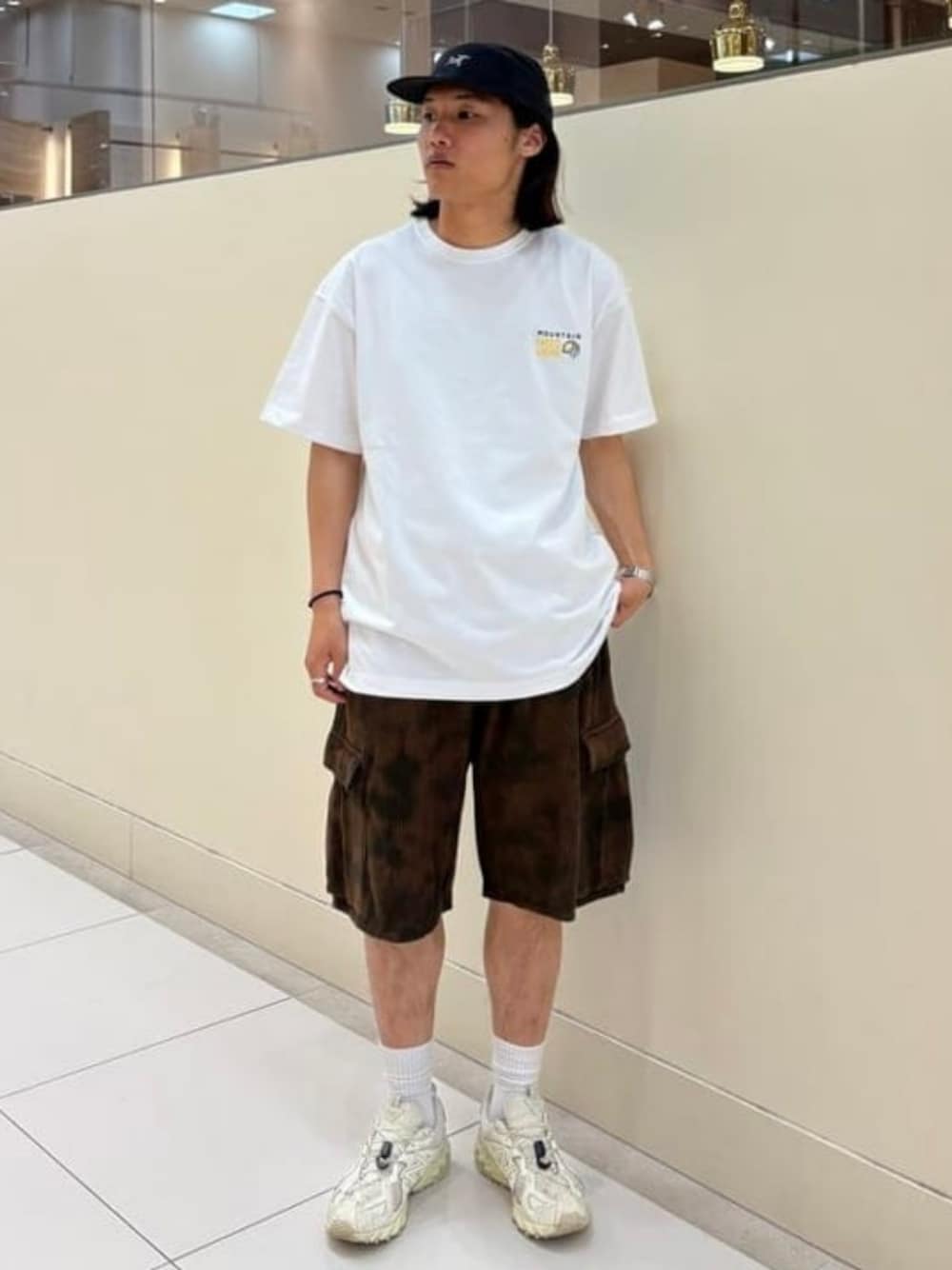 ホワイト系のTシャツ/カットソー、ブラウン系のカーゴパンツを着用したメンズの春コーディネートの1枚目の写真