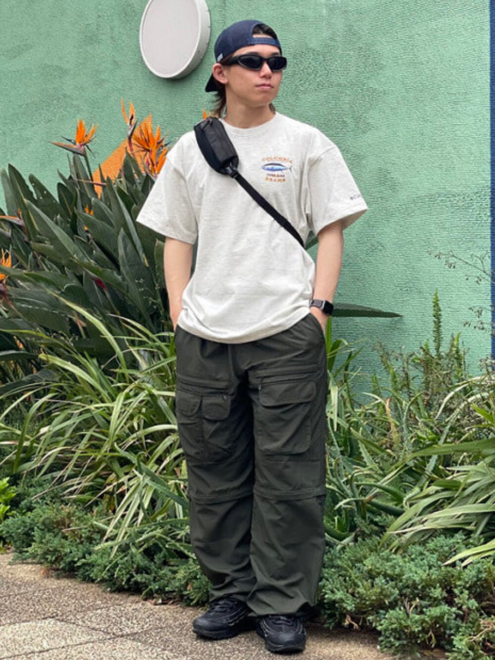 シルバー系のTシャツ/カットソー、グリーン系のその他パンツ、ブルー系のキャップを着用したメンズの春コーディネートの1枚目の写真