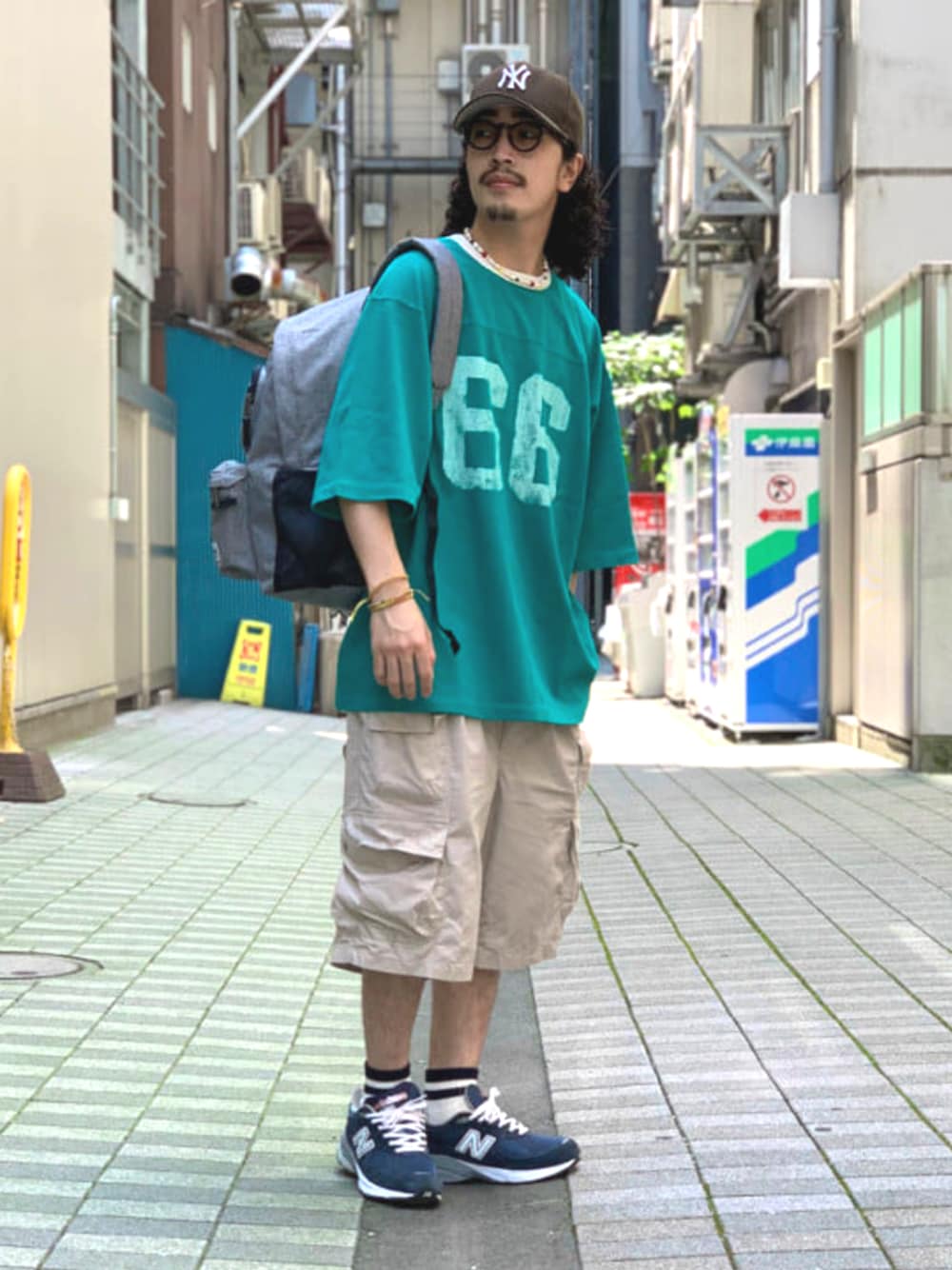 グレー系のバックパック/リュック、ベージュ系のその他パンツ、グリーン系のTシャツ/カットソーを着用したメンズの夏コーディネートの1枚目の写真