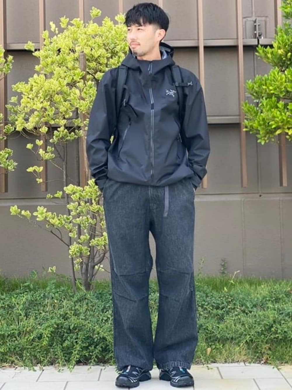 ブラック系のデニムパンツ、ブラック系のバックパック/リュック、ブラック系のブルゾンを着用したメンズの夏コーディネートの1枚目の写真