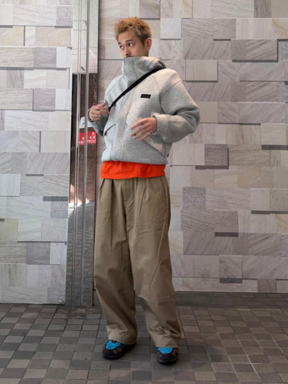 グレー系のパーカー、ベージュ系のその他パンツを着用したメンズの冬コーディネートの1枚目の写真