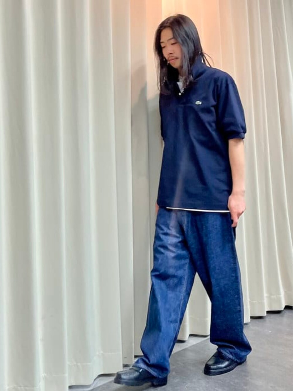 ブルー系のデニムパンツ、ブルー系のポロシャツ、ホワイト系のTシャツ/カットソーを着用したメンズの春コーディネートの1枚目の写真