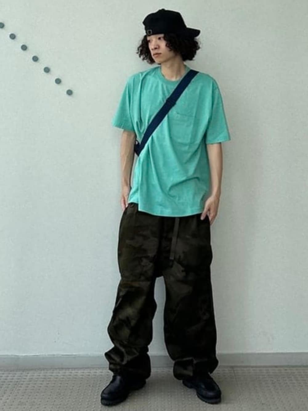 グリーン系のカーゴパンツ、グリーン系のTシャツ/カットソー、ブルー系のショルダーバッグを着用したメンズの夏コーディネートの1枚目の写真
