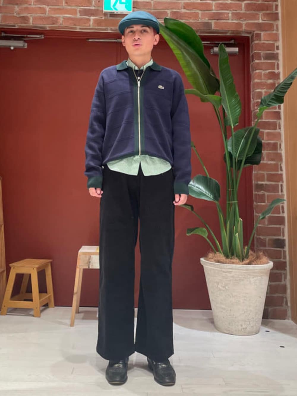 ブラック系のその他パンツ、ブルー系のニット/セーター、グリーン系のキャスケットを着用したメンズの秋コーディネートの1枚目の写真