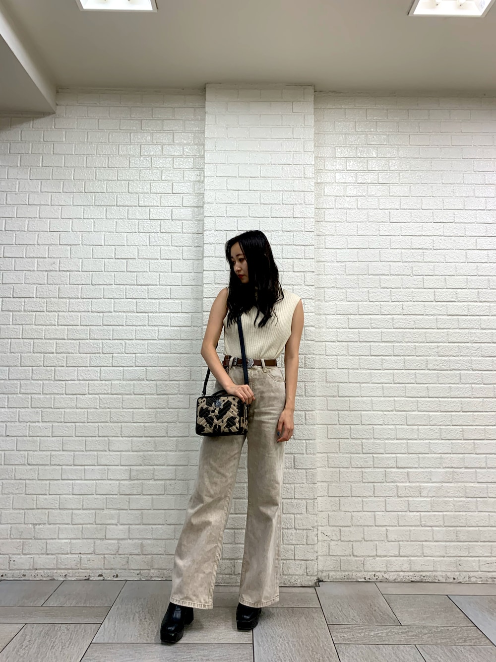 その他のハンドバッグ、ホワイト系のタンクトップ、ベージュ系のデニムパンツを着用したレディースの夏コーディネートの1枚目の写真