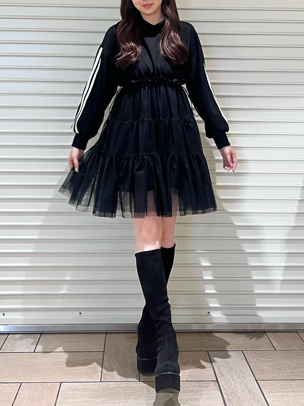 ブラック系のワンピース、ブラック系のブーツを着用したレディースの秋コーディネートの1枚目の写真