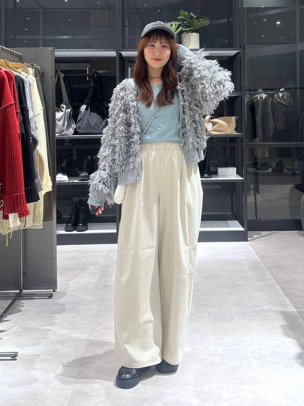 ブラック系のサンダル、ブルー系のTシャツ/カットソー、グレー系のニット/セーターを着用したレディースの秋コーディネートの1枚目の写真