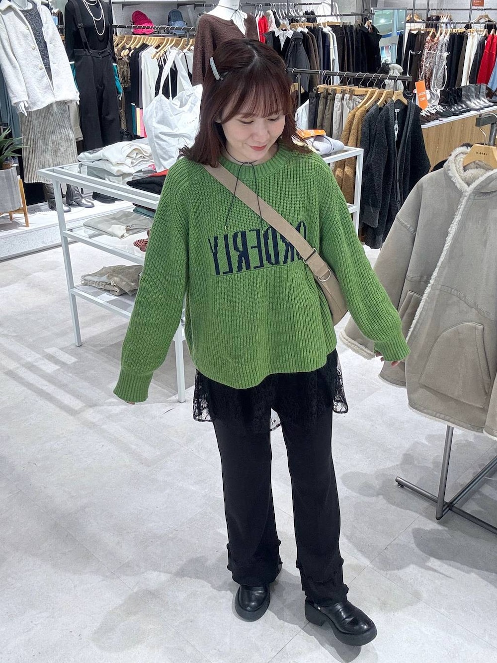 ベージュ系のショルダーバッグ、ブラック系のサンダル、ブラック系のブルゾンを着用したレディースの冬コーディネートの1枚目の写真