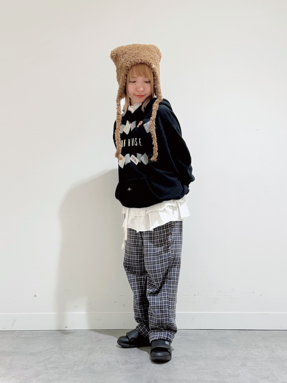 ブラック系のパーカー、ブルー系のパンツ、ブラック系のスニーカーを着用したレディースの冬コーディネートの1枚目の写真