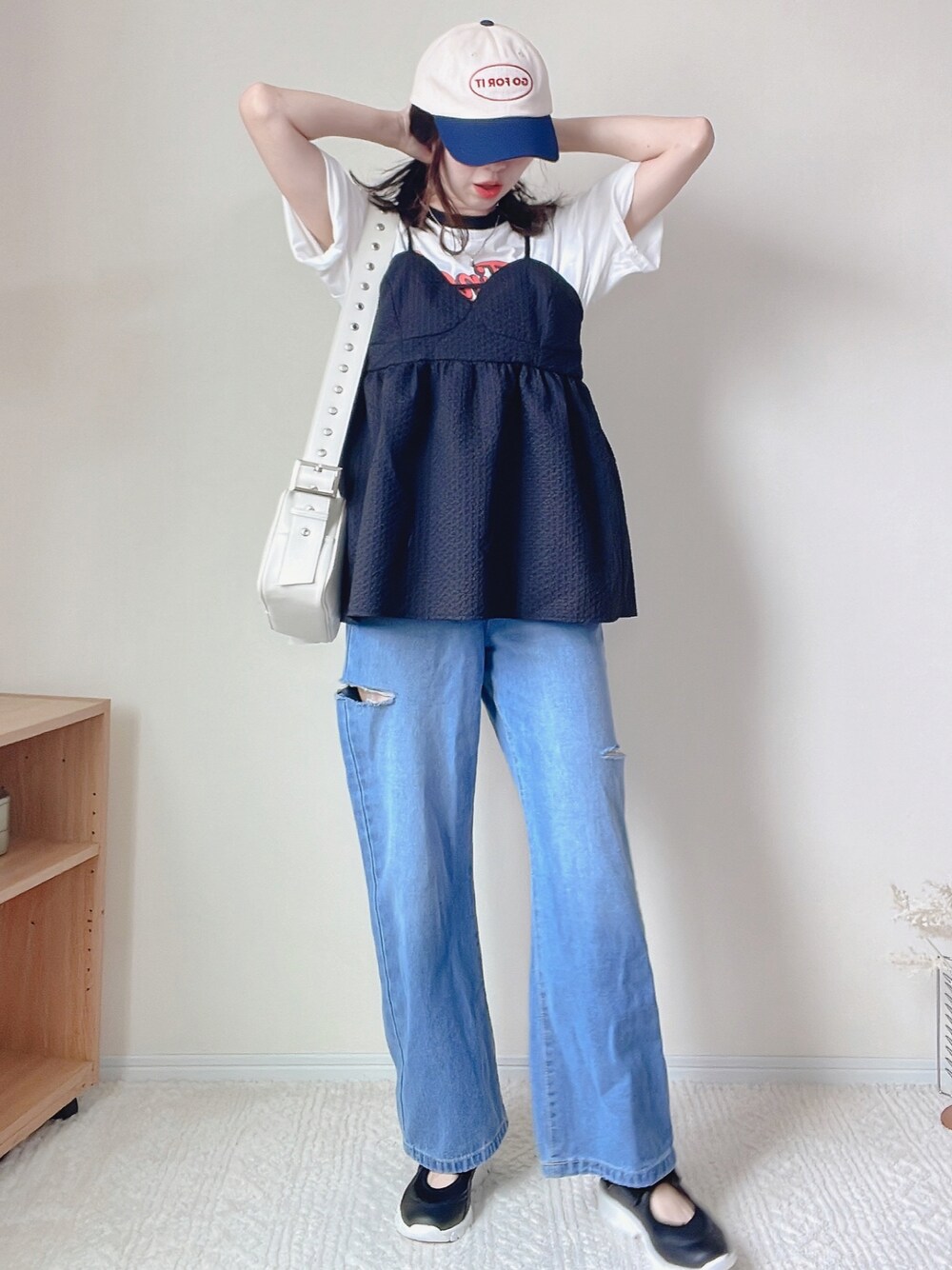 ブルー系のデニムパンツ、ブラック系のその他トップス、ホワイト系のTシャツ/カットソーを着用したレディースの春コーディネートの1枚目の写真