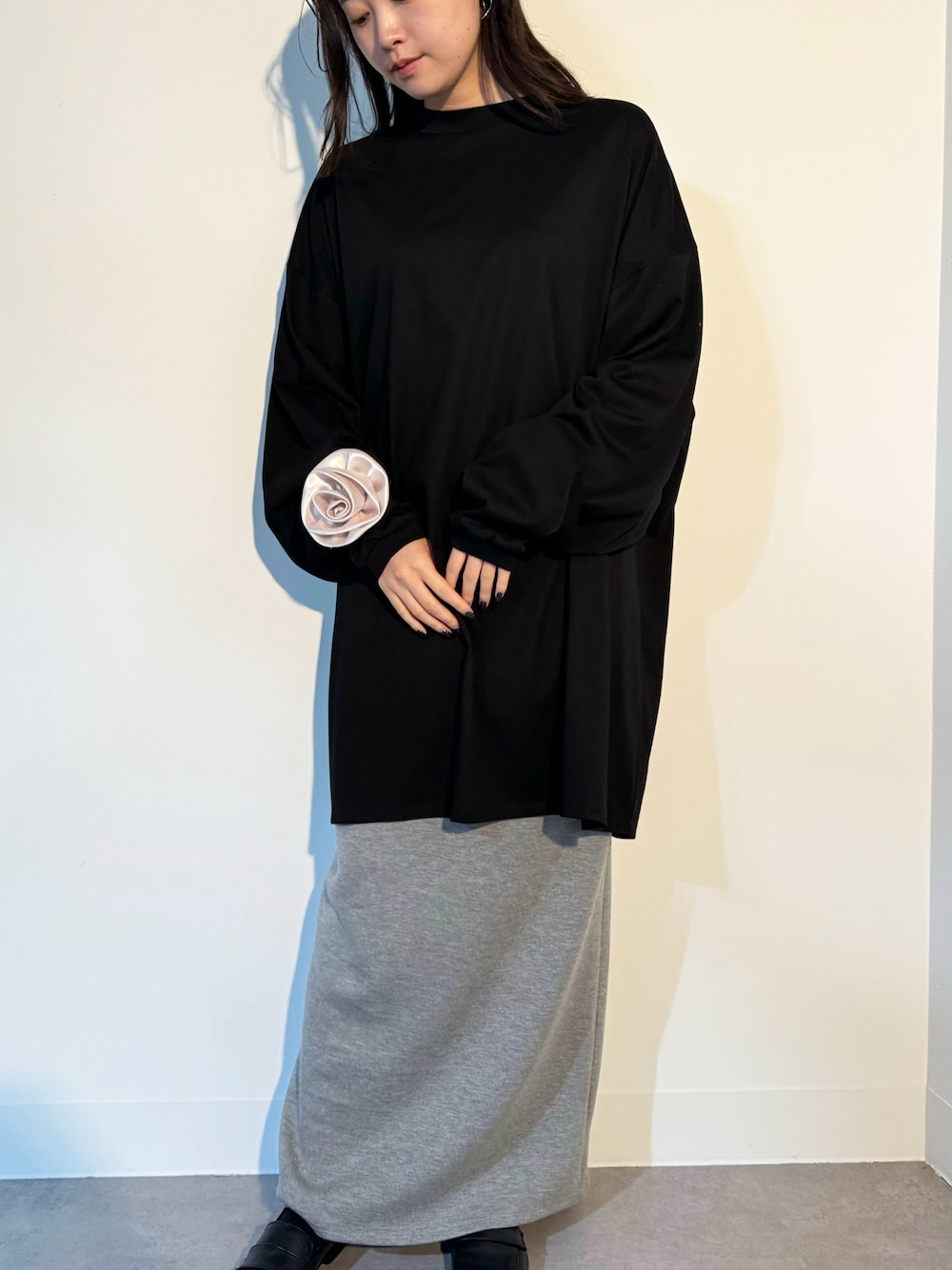 ブラック系のTシャツ/カットソー、グレー系のスカート、ベージュ系のシュシュを着用したレディースの秋コーディネートの1枚目の写真