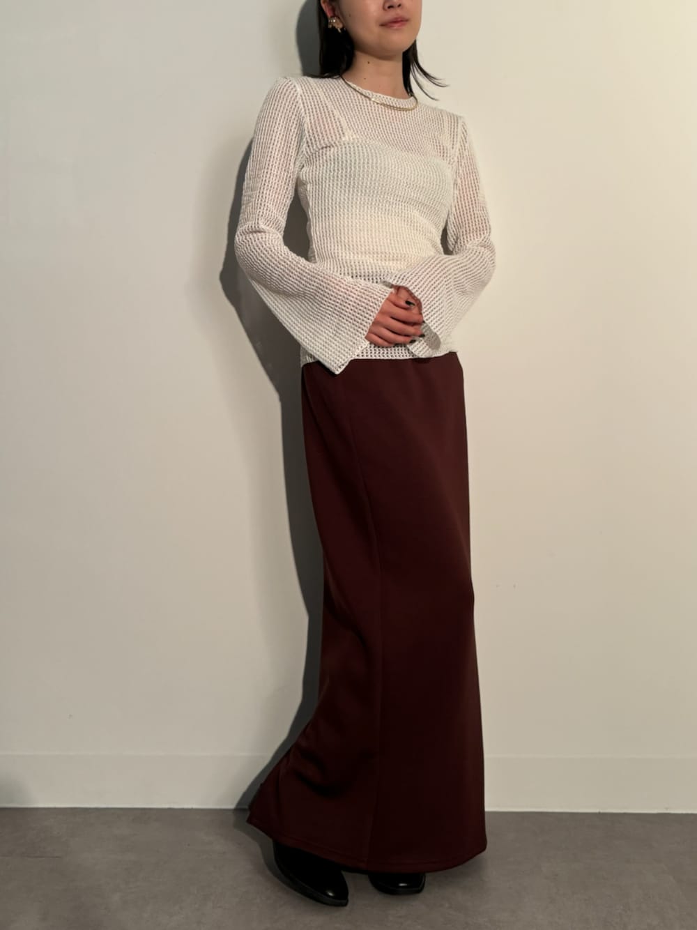 ホワイト系のTシャツ/カットソー、ブラウン系のスカート、ゴールド系のイヤーカフを着用したレディースの秋コーディネートの1枚目の写真