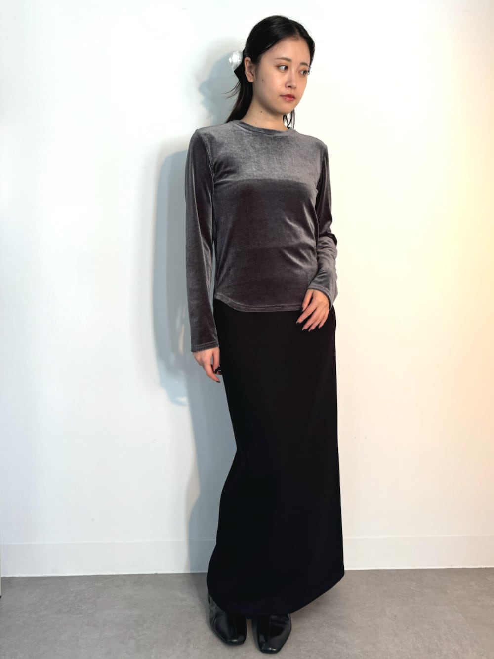 ブラック系のスカート、グレー系のTシャツ/カットソー、シルバー系のイヤーカフを着用したレディースの秋コーディネートの1枚目の写真