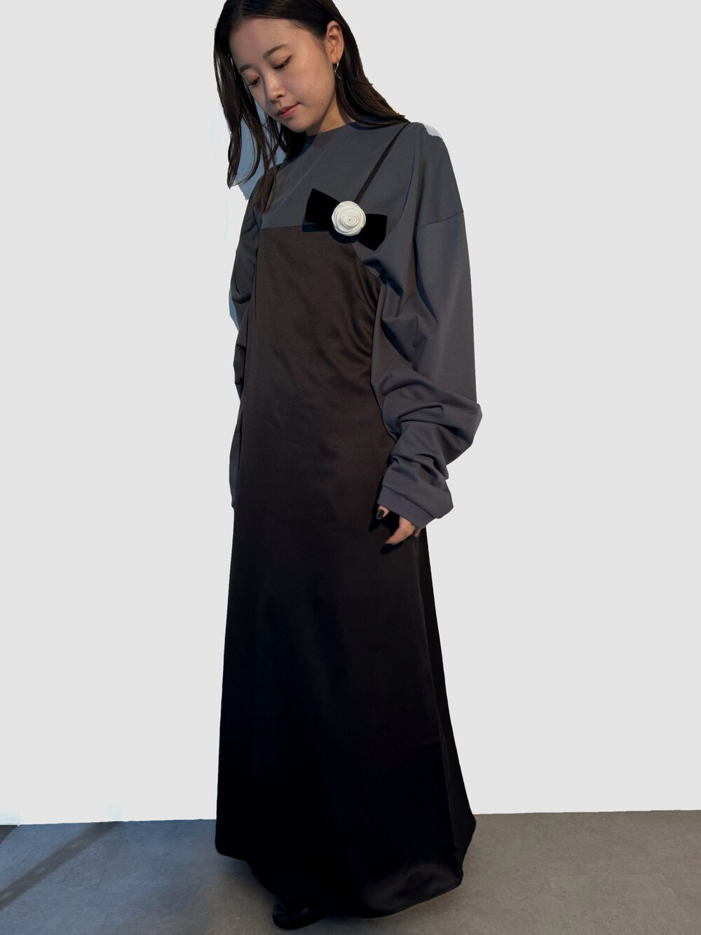 ブラック系のワンピース、グレー系のTシャツ/カットソー、シルバー系のピアス(両耳用)を着用したレディースの秋コーディネートの1枚目の写真