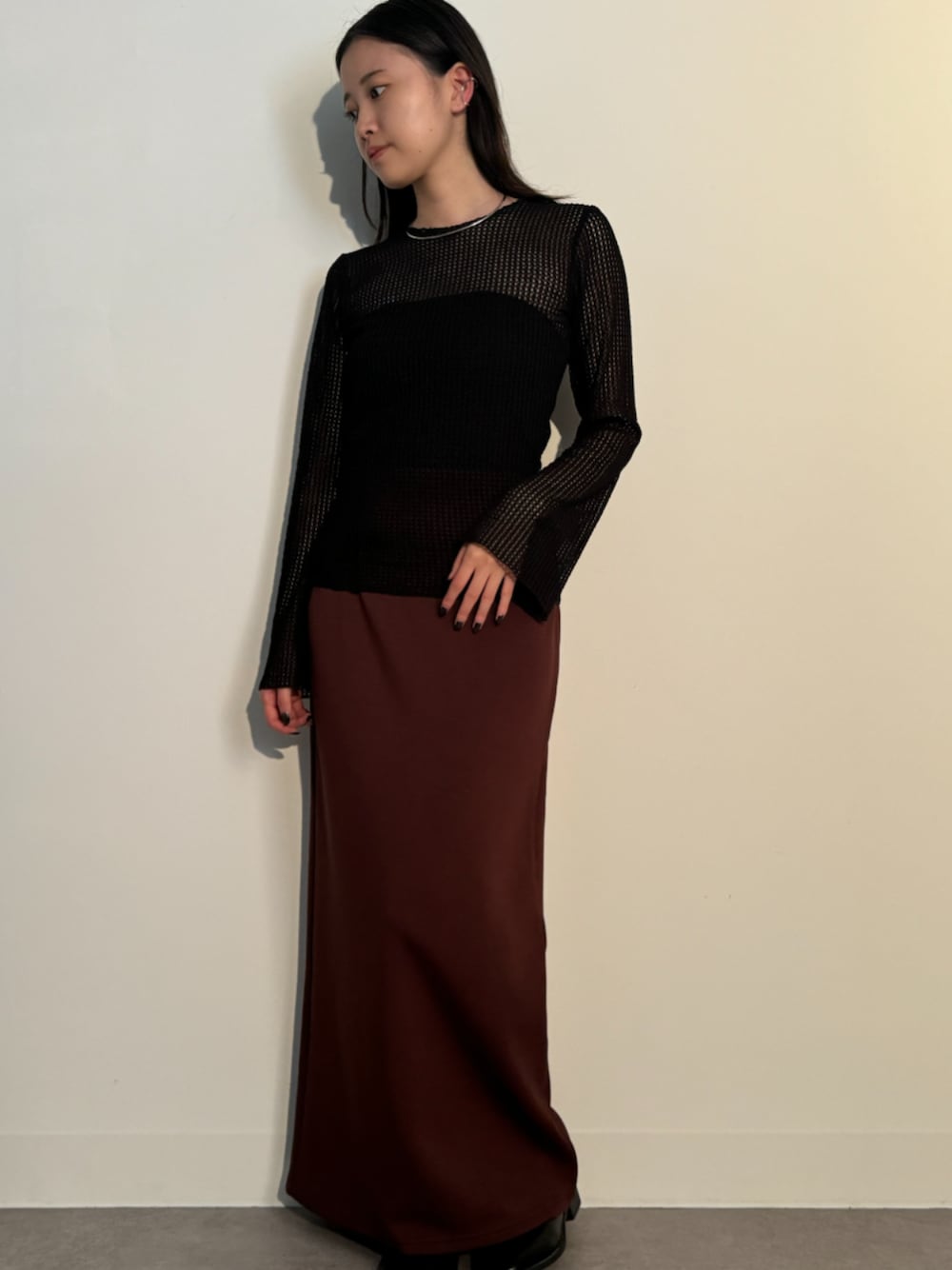 ブラック系のTシャツ/カットソー、ブラウン系のスカート、シルバー系のネックレスを着用したレディースの秋コーディネートの1枚目の写真