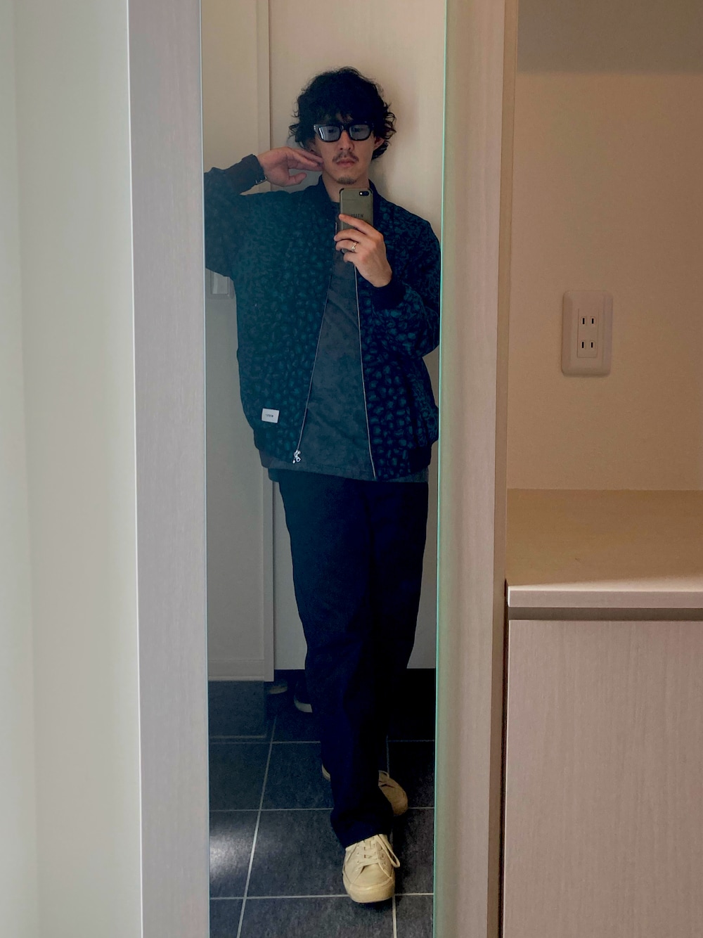 グレー系のTシャツ/カットソー、ブラック系のチノパンツ、グリーン系のブルゾンを着用したメンズの秋コーディネートの1枚目の写真