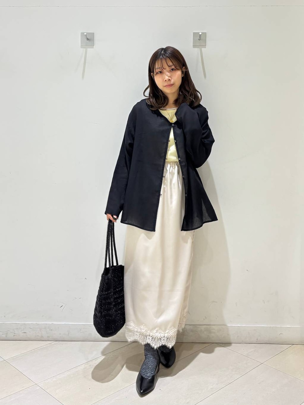 ブラック系のパンプス、ブラック系のクラッチバッグ、ブラック系のカーディガン/ボレロを着用したレディースの夏コーディネートの1枚目の写真