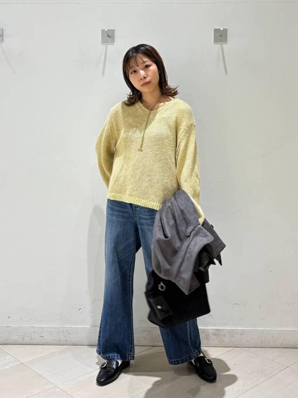 ブラック系のローファー、ブラック系のトートバッグ、ブルー系のデニムパンツを着用したレディースの春コーディネートの1枚目の写真