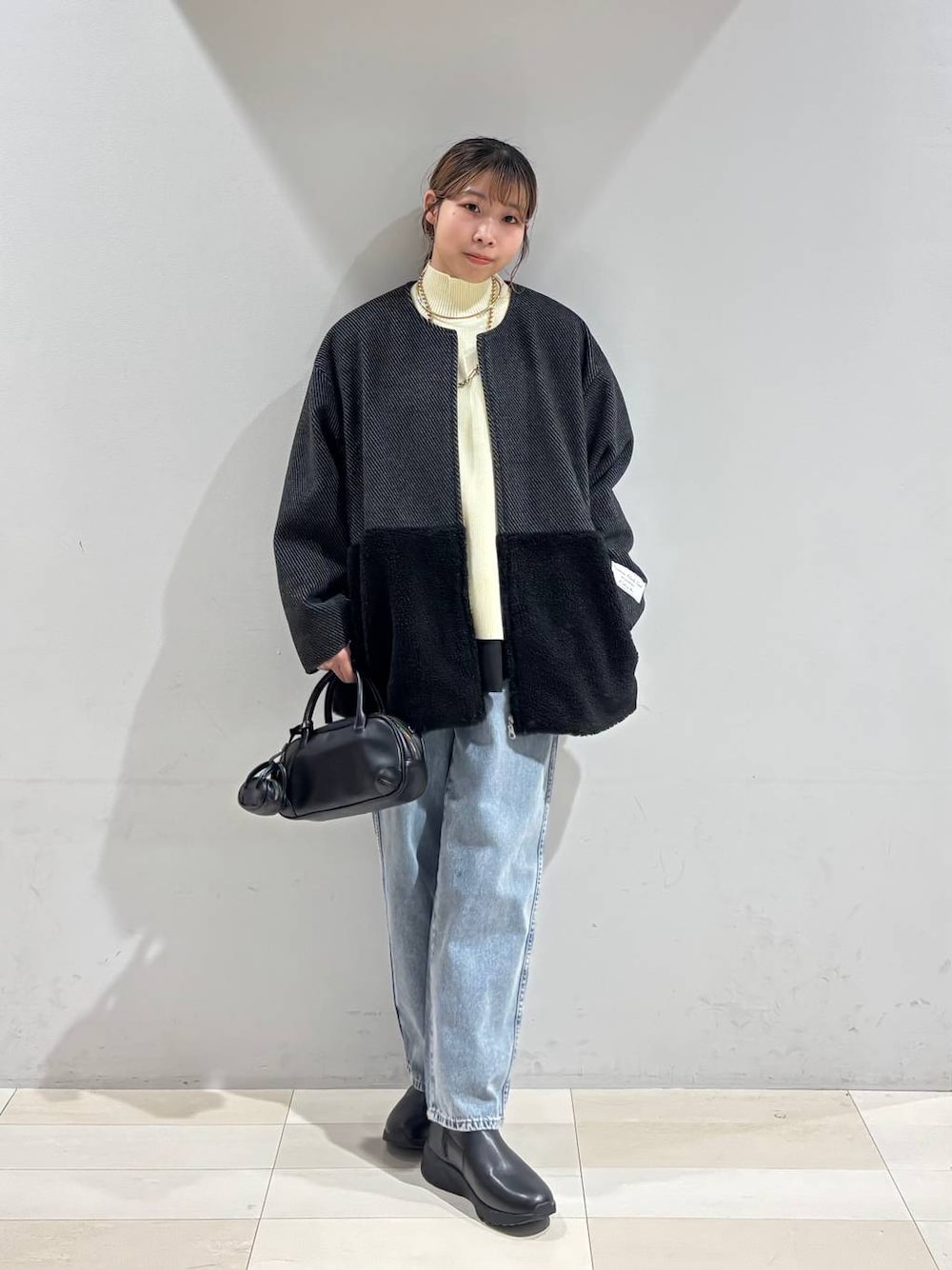 ブルー系のデニムパンツ、ブラック系のブーツ、ブラック系のTシャツ/カットソーを着用したレディースの冬コーディネートの1枚目の写真