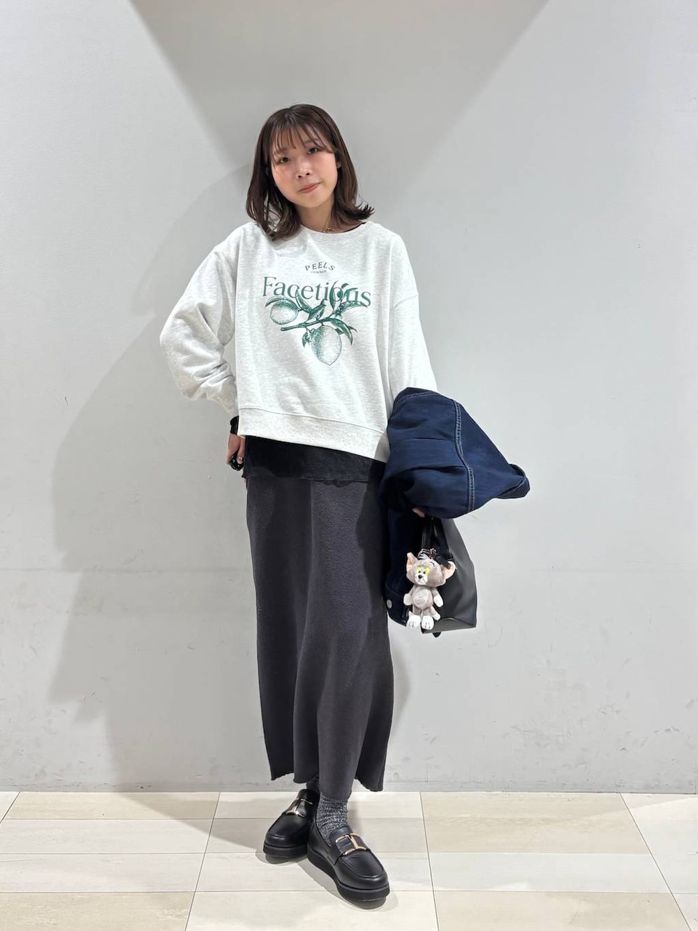 ブラック系のショルダーバッグ、ブラック系のローファー、ブラック系のTシャツ/カットソーを着用したレディースの冬コーディネートの1枚目の写真