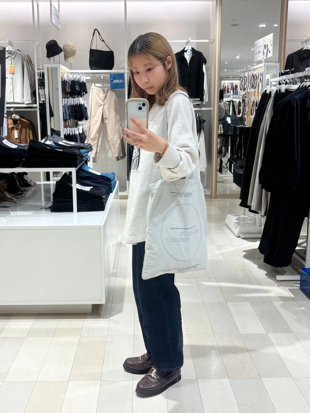 ブラウン系のローファー、ブルー系のデニムパンツ、グレー系のTシャツ/カットソーを着用したレディースの秋コーディネートの1枚目の写真