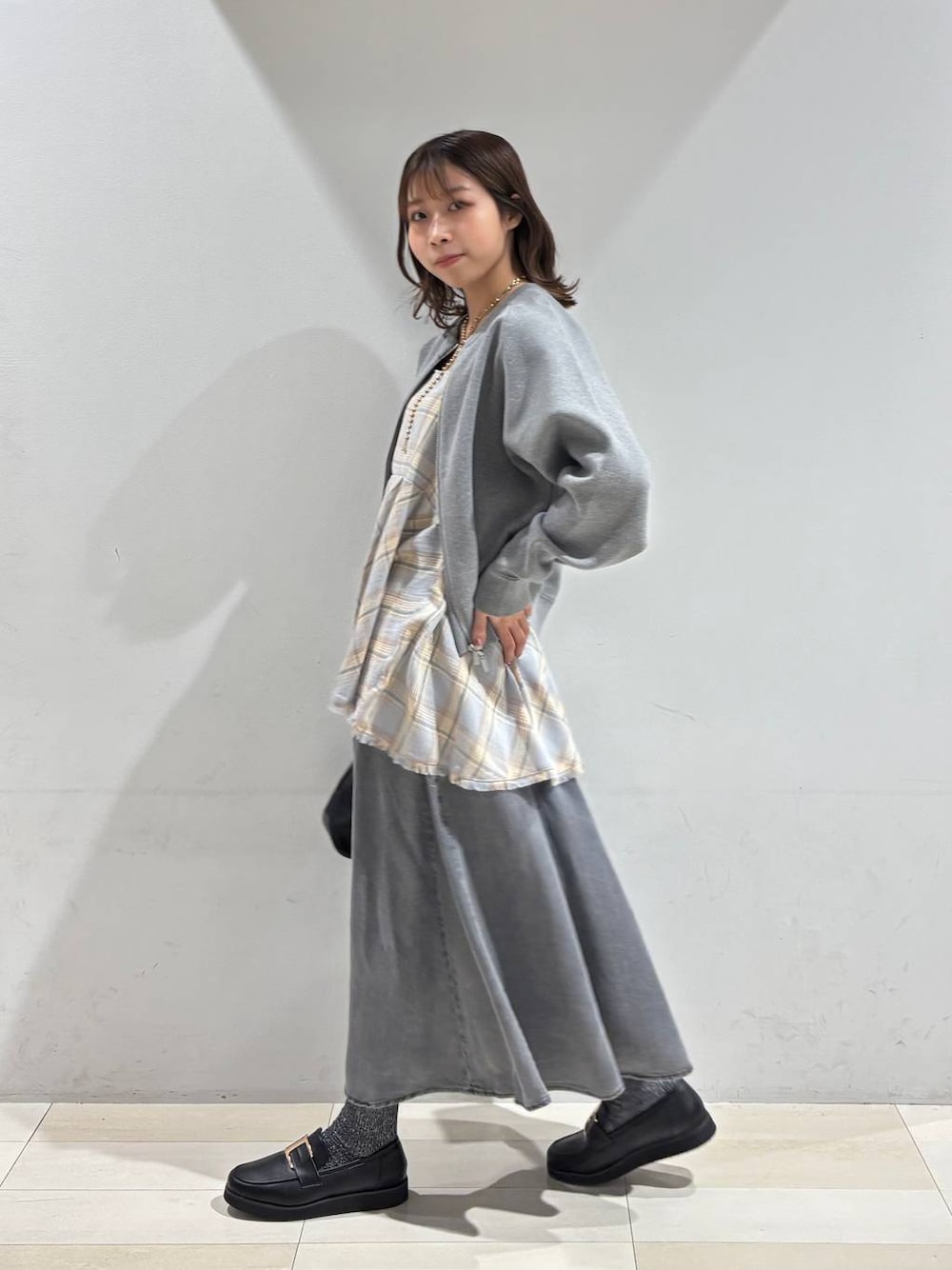 ブラック系のショルダーバッグ、ブラック系のローファー、ブルー系のその他トップスを着用したレディースの春コーディネートの1枚目の写真