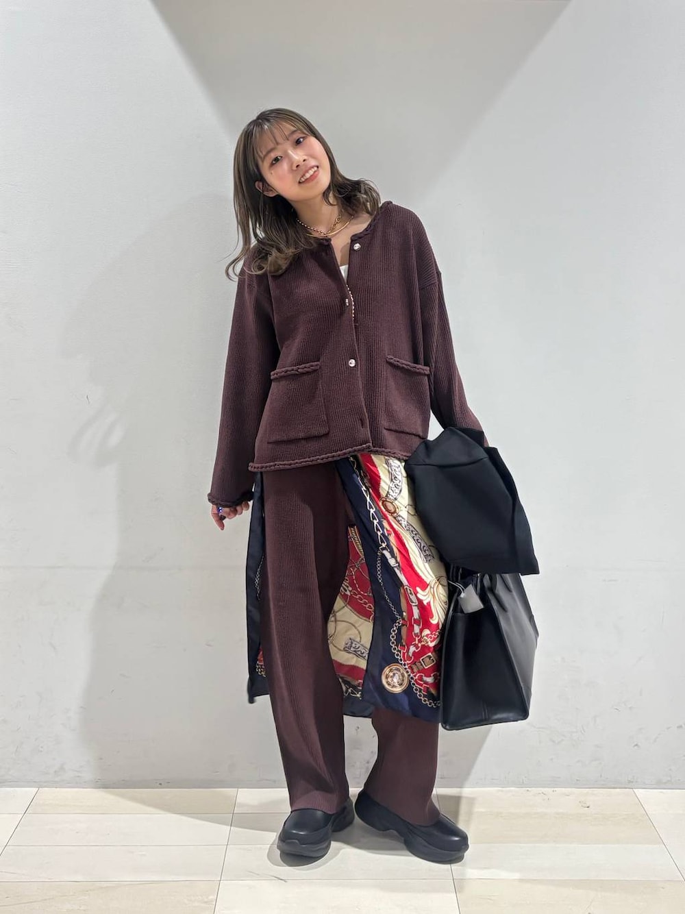 ホワイト系のキャミソール、ブラック系のトートバッグ、ブラック系のテーラードジャケットを着用したレディースの秋コーディネートの1枚目の写真