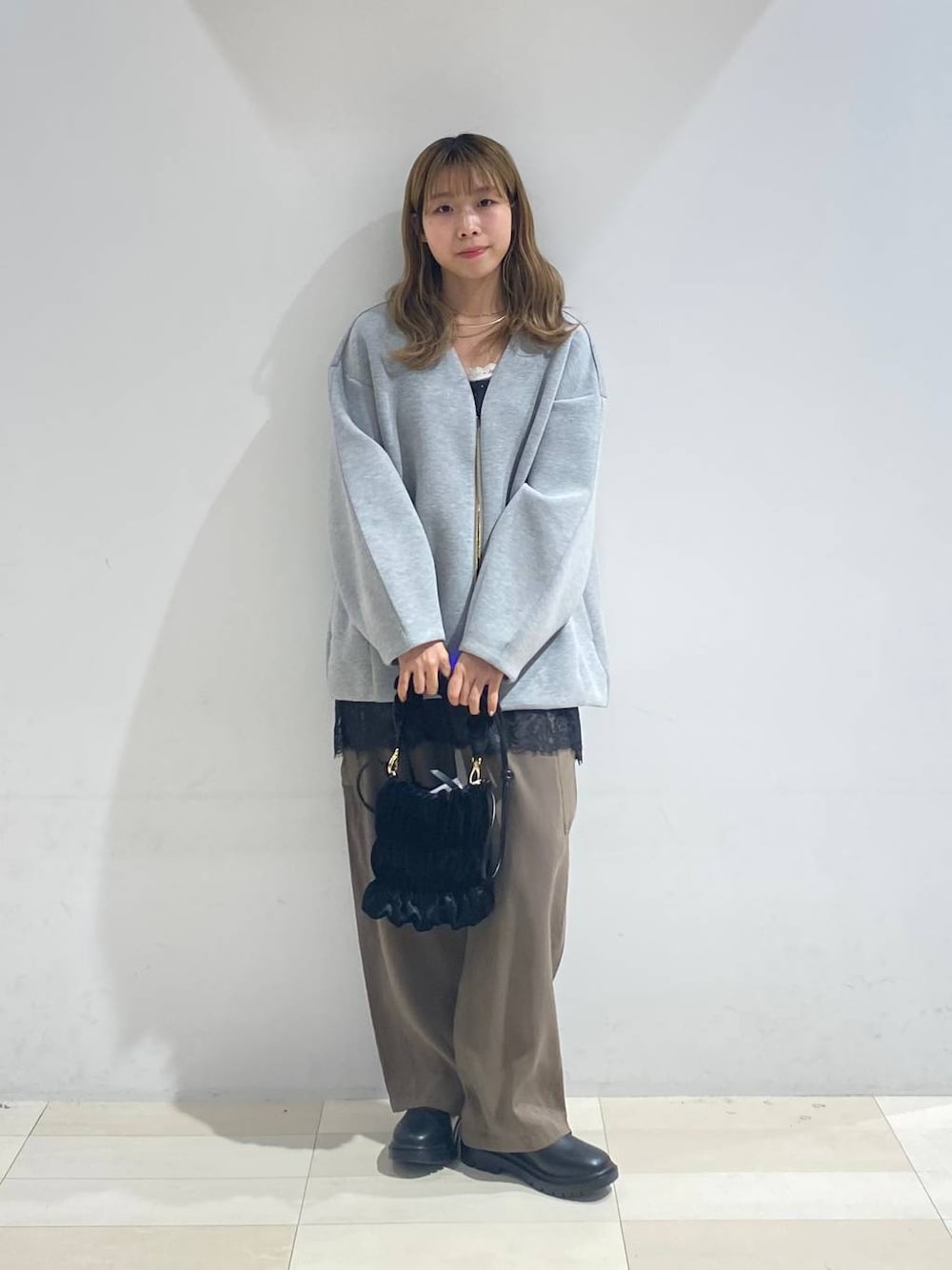 グリーン系のその他パンツ、ブラック系のブーツ、ホワイト系のキャミソールを着用したレディースの秋コーディネートの1枚目の写真