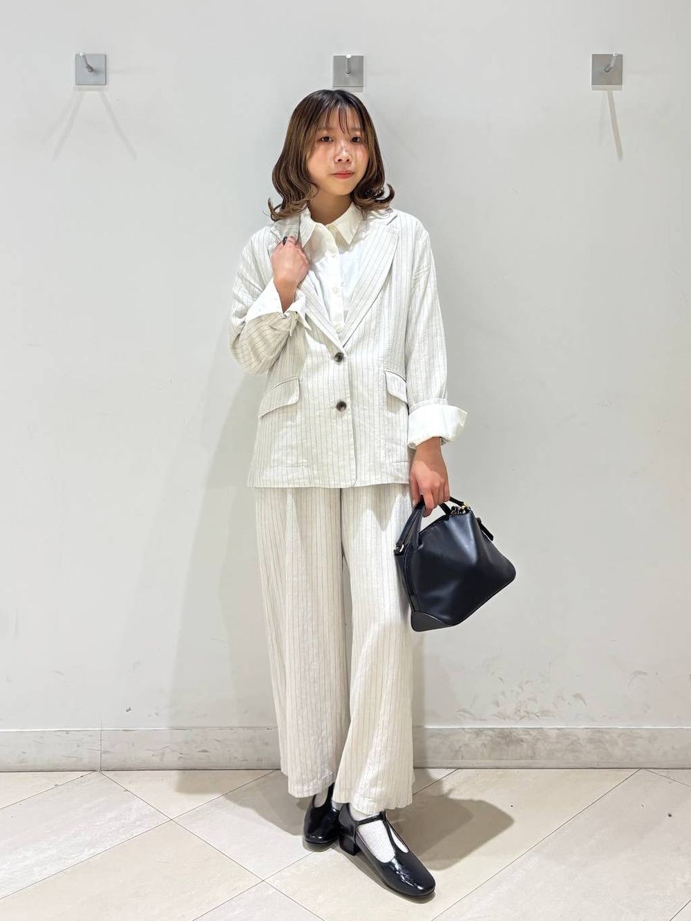 ブラック系のショルダーバッグ、ベージュ系のその他パンツ、グレー系のテーラードジャケットを着用したレディースの春コーディネートの1枚目の写真