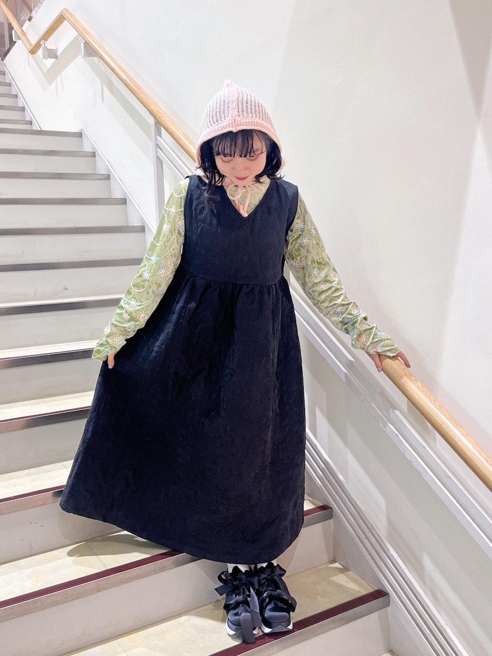 ブラック系のワンピース、ブラック系のスニーカー、グリーン系のTシャツ/カットソーを着用したレディースの秋コーディネートの1枚目の写真